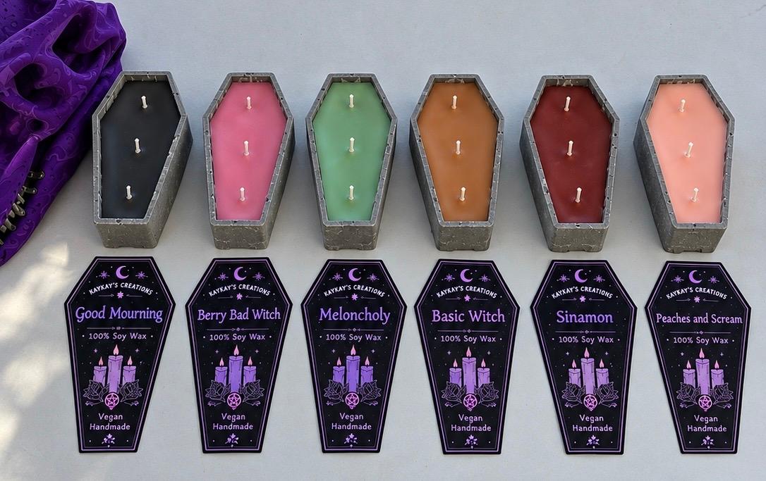 Six coffin-shaped candles labeled Good Mourning, Berry Bad Witch, Meloncholy, Basic Witch, Sinamon, and Peaches and Scream